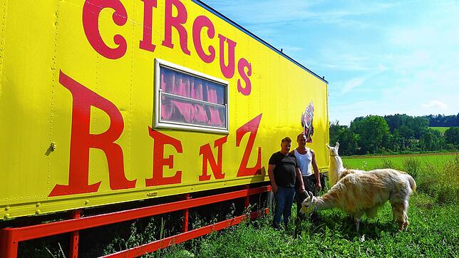Zirkuschef René Renz (links) mit Sohn Remo und den Lamas Maja und Bianca vor einem frisch gestrichenen Wagen der Familie.