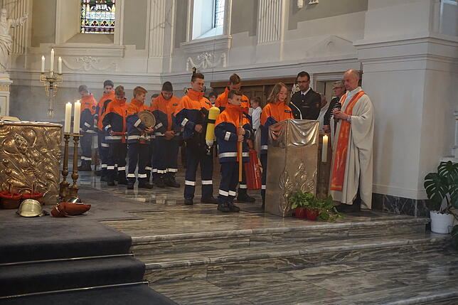 Mit ihren Feuerwehrutensilien verlass die Jugendfeuerwehr die Fürbitten.