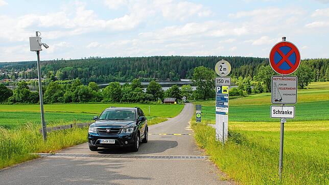Anfahrt zum Südufer des Kirnbergsees: Eine Kamera (links) scannt die Nummernschilder der Fahrzeuge beim Ein- und Ausfahren. Auf großen ...