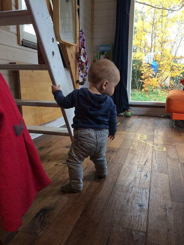Der kleine Adam lernt im Tiny House laufen.