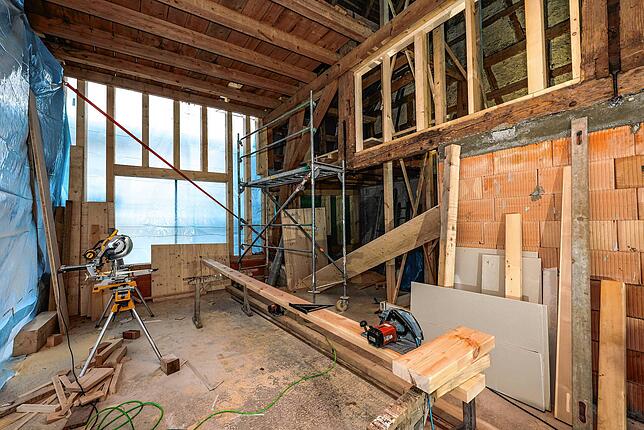 In der Scheune sind Handwerker unter anderem damit beschäftigt, Holz zurechtzuschneiden.