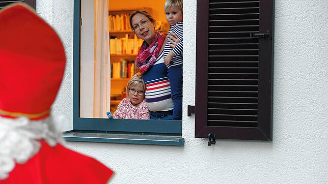 Sarah, Nina und Maria Schobloch (von links) warten am Fenster auf Sankt Nikolaus. Die sechsjährige Sarah hat für ihn ein Bild gemalt.