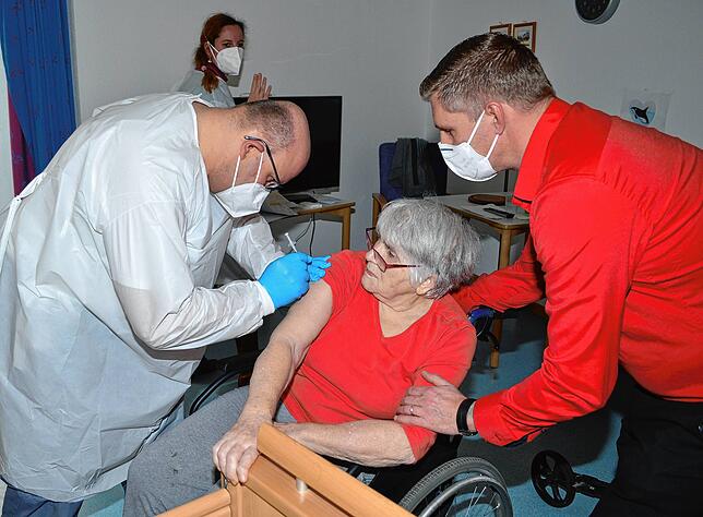 Notfallsanitäter Jörg Behringer (links) impft in Königsfeld die 83-jährige Bewohnerin Rosemarie Borowski. Pflegedienstleiter Matthias ...