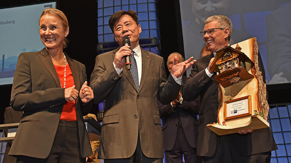 Bei der Übergabe einer Kuckucksuhr durch Thomas Weisser (rechts) fragt sich Botschafter Wu Ken (Mitte), ob der Kuckuck auch Chinesisch ...