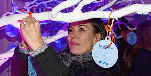 Neri Zena aus VS-Schwenningen hängt ihren Zettel an den SÜDKURIER-Wunschbaum.