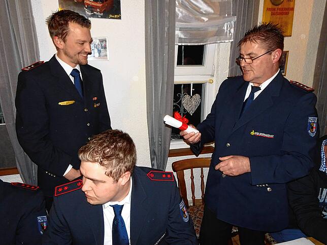 Kommandant Ritsche ehrt seinen nach zwölf Amtsjahren scheidenden Stellvertreter Mathias Bernhard (links). Vorn sitzend Schriftführer ...