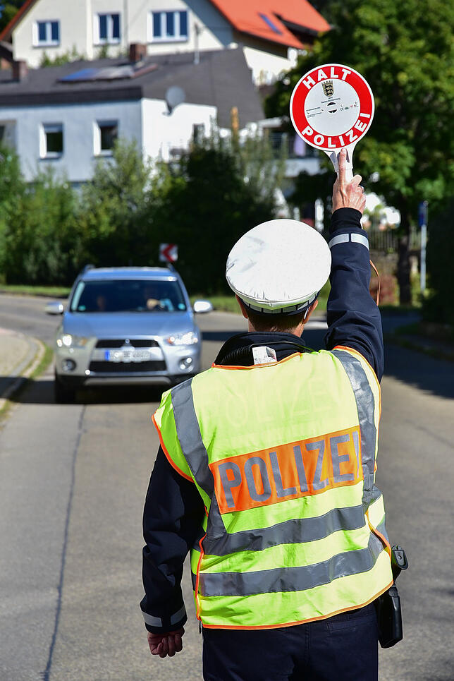 Eine Polizistin winkt ein Fahrzeug zur Kontrolle heraus. Ein Glück für die Verkehrsteilnehmer, das Fehlverhanten bleibt an diesem Tag ...
