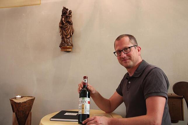 Pfarrer Robert Geßmann hält den Baustein-Bauwein in Händen, der anlässlich der geplanten Sanierung der alt-katholischen Kirche St. ...
