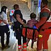 Helfer aus Dennenmosers Team transportieren in Mykolajiw eine gehbehinderte Frau eine Treppe hinauf.