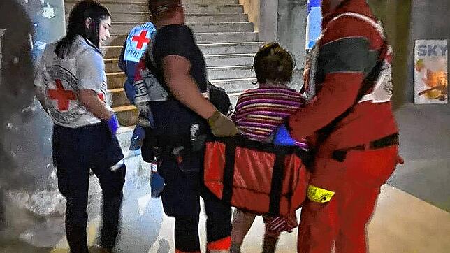 Helfer aus Dennenmosers Team transportieren in Mykolajiw eine gehbehinderte Frau eine Treppe hinauf.