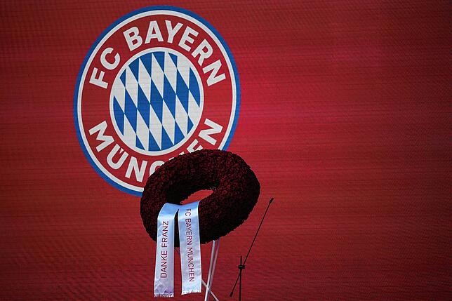 Ein Kranz mit der Aufschrift &bdquo;FC Bayern München&ldquo; &bdquo;Danke Franz&ldquo; ist auf der Rednertribüne zu sehen.