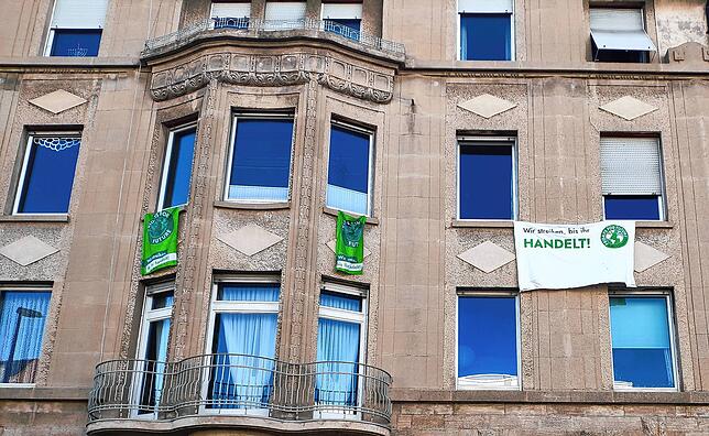 „Wir streiken, bis ihr handelt“ steht rechts auf dem weißen Plakat an der Hausfassade auf der Laube. Auf den grünen links ...