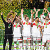 Stuttgarts Atakan Karazor hält die Trophäe in die Höhe und jubelt mit seinen Mitspielern über den Pokalsieg.