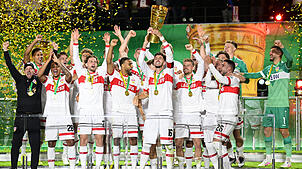 Stuttgarts Atakan Karazor hält die Trophäe in die Höhe und jubelt mit seinen Mitspielern über den Pokalsieg.