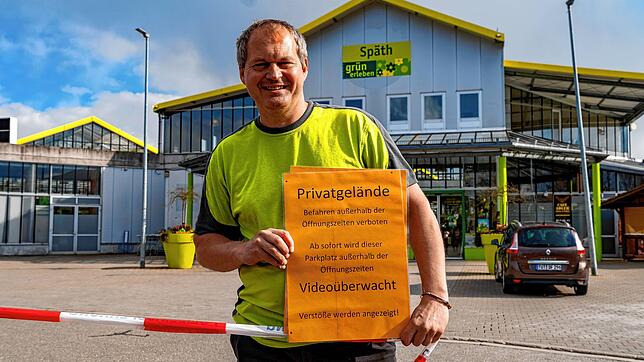 Geschäftsführer Thomas Wiedmann vom Gartencenter Späth zeigt eines seiner Hinweisschilder, womit auf den gesperrten Parkplatz außerhalb ...