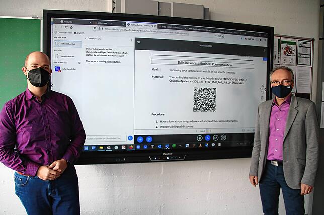 Lehrer Daniel Hohe (links) und Norbert Kias-Kümpers, Schulleiter der Gewerblichen Schulen, stehen vor einer digitalen Tafel.