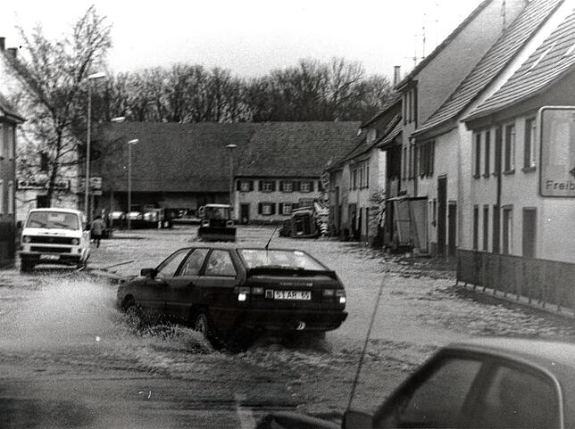 Autos kämpfen sich 1990 auf der gesamten Baar durch die Wassermassen.