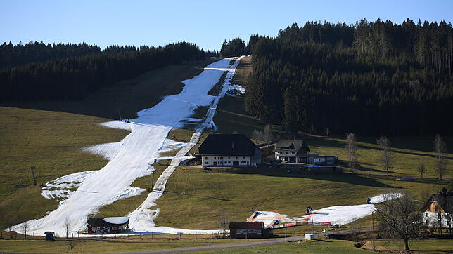 Kunstschnee liegt am Schneeberglift zwischen grünen Wiesen und Wäldern. Skiliftbetreiber im Südwesten hoffen auf Schnee, bislang waren ...