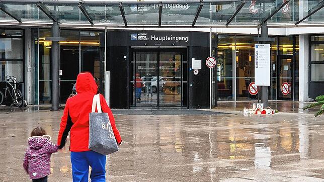 Der Haupteingang des Klinikums in Friedrichshafen im Dezember 2023. Rechts stehen Kerzen, die Menschen in Gedenken an die verstorbene ...