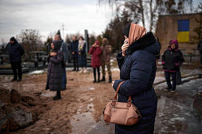 Der Krieg in der Ukraine tobt auch kurz vor Weihnachten unvermindert weiter. Hier versammeln sich in Butscha Angehörige und Freunde bei ...