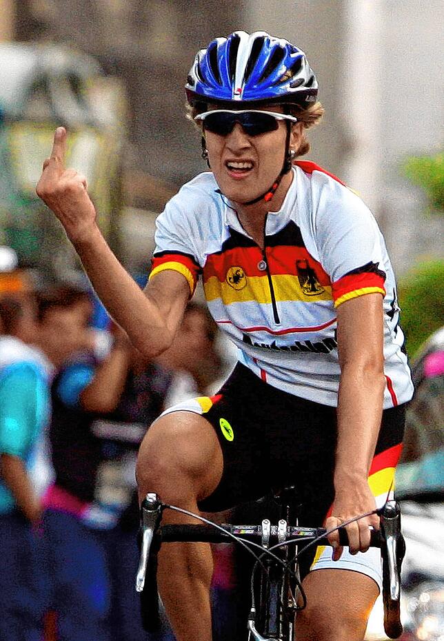 Die deutsche Radrennfahrerin Judith Arndt zeigt 2004 in Athen bei der Zieleinfahrt des olympischen Straßenradrennens ihrem Verband den ...