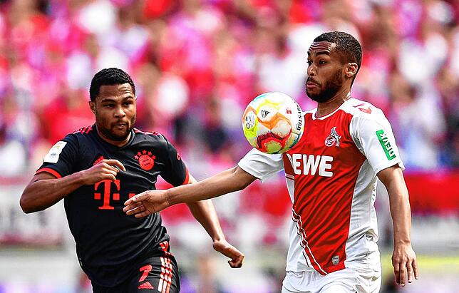 Bayerns Serge Gnabry (l) und Kölns Linton Maina kämpfen um den Ball.