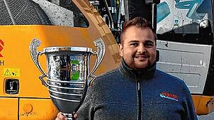 Robin Müller ist zweimaliger Europameister im Baggerfahren. Hier zeigt er stolz seinen EM-Pokal.