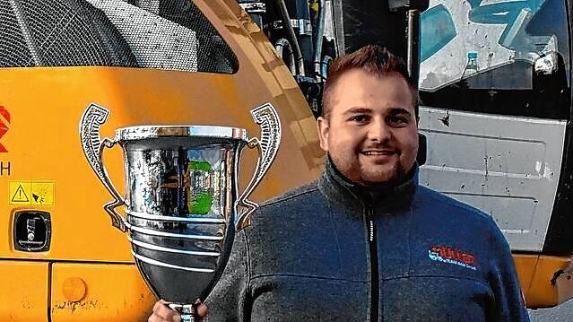 Robin Müller ist zweimaliger Europameister im Baggerfahren. Hier zeigt er stolz seinen EM-Pokal.