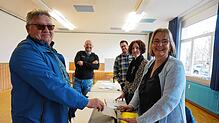 Der Nöggenschwieler Manfred Ebe (links) steckt seinen Wahlzettel in die Urne bei den Wahlhelfern Margit Böhler, Angelika Eckert, ...