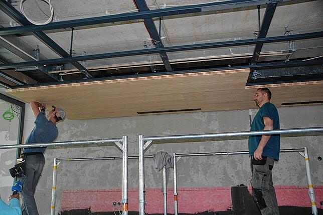 Fleißig montieren die Arbeiter die vielen Holzdecken, die noch in einigen Bereichen fehlen.