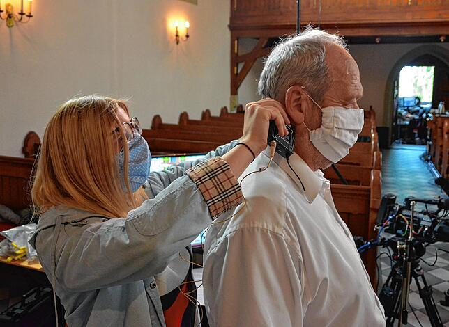 Tonassistentin Michaela Hartmann legt Lektor Uwe Priebe das Mikrofon an.
