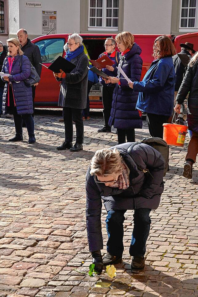 Gabriele Lee-Engelke vom Verein Pro Stolpersteine legt eine weiße Rose an den frisch eingesetzten Stolperstein von Ewald Huth.