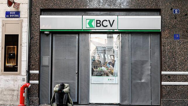 Ein Bettler sitzt im Schweizer Lausanne vor einer Bankfiliale auf dem Boden.