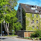 Über die Jahre eingewachsener Chérisy-Block, in dem sich WGs in hohen Räumen und an langen Fluren befinden.