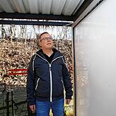 Markus Buntru steht vor einer Werbevitrine, deren Glasscheibe zerstört wurde.