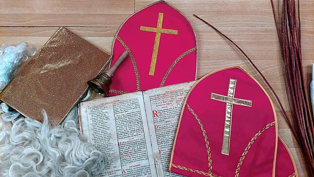 Rauschebart, goldenes Buch, Mitra und Glocke gehören zur Ausstattung des Nikolauses.