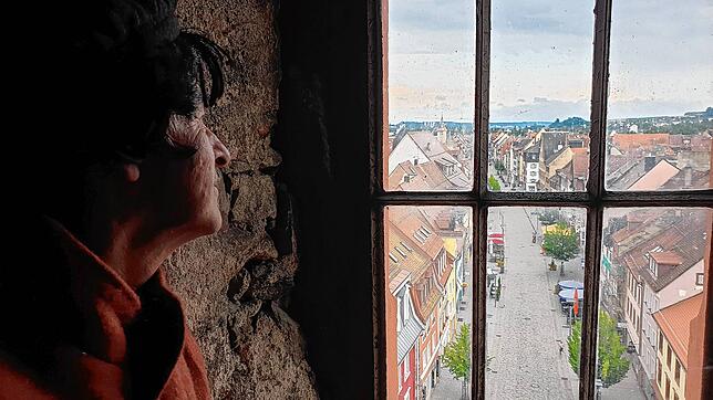 Stadtführer Klaus Richter in historischem Gewand blickt aus dem Turm des Oberen Tores über die Stadt Villingen mit der Oberen Straße.