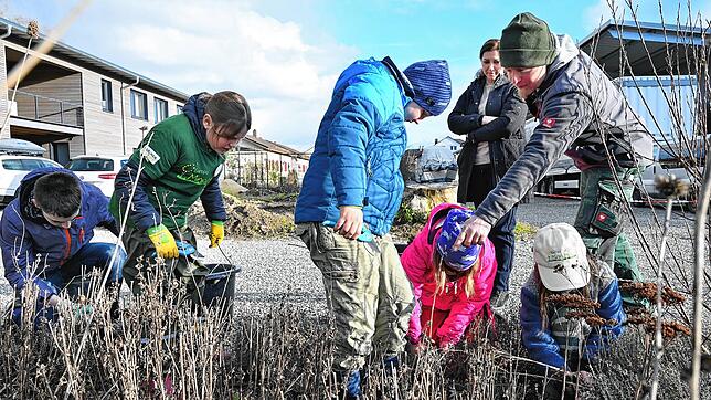 Gartenbaumeister Stefan Hirt (rechts) zeigt den Minigärtnern, auf welche Dinge sie beim Schneiden der Stauden achten müssen.
