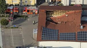 Ein Luftbild zeigt das teilweise eingestürzte Dach des Rewe-Supermarktes von oben.