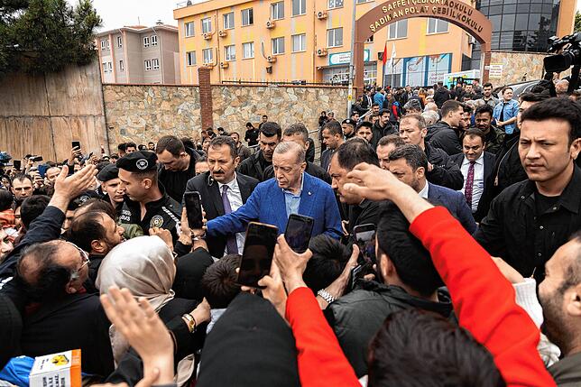 Erdogan inmitten seiner Anhänger vor einem Wahllokal.