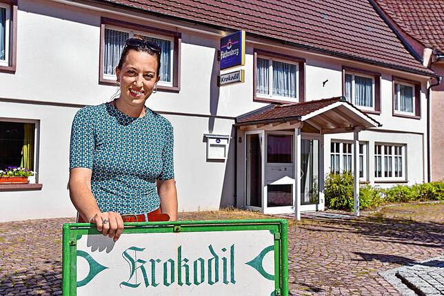 Die neue Krokodil-Wirtin hinter dem Wirtshausschild