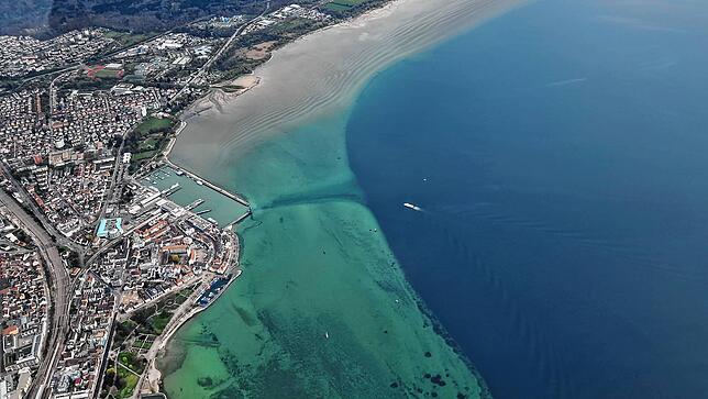 Friedrichshafen von oben. Gut zu erkennen ist der zunächst flache Grund des Bodensees, der dann in die Tiefe abfällt.