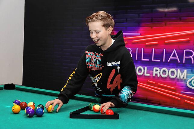 Am Billiardtisch in der Nachsorgeklinik Tannheim sortiert der 14-jährige Joris die Kugeln für ein kurzes Spiel mit seinen Geschwistern.