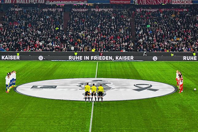 Die gleiche Aufschrift ist auch auf der Bande zu lesen, während die Mannschaften und die Zuschauer im Stadion eine Schweigeminute für ...