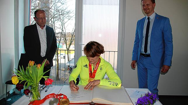 Monobobskifahrerin Anna-Lena Forster (Mitte) trägt sich ins goldene Buch der Stadt Radolfzell ein. Mit im Bild: Der Stahringer ...