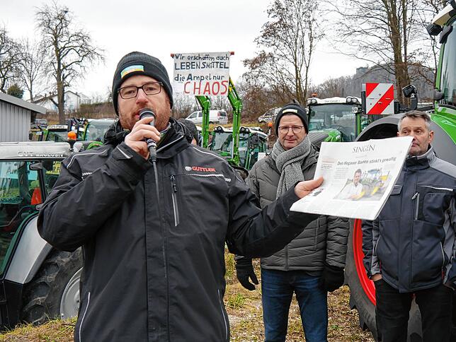 Organisator Stefan Leichenauer zeigt die aktuelle SÜDKURIER-Ausgabe, die gut zusammenfasse, was Landwirte aktuell beschäftigt.