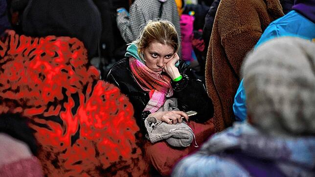 Eine Frau, die vor dem Krieg aus der benachbarten Ukraine geflohen ist, wartet an einem Bahnhof im polnischen Przemysl. Viele Ukrainer ...