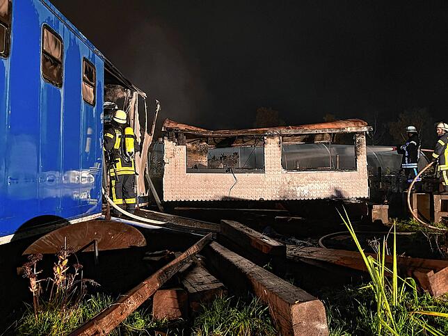 Bauwagen und Anhänger werden ein Raub der Flammen.