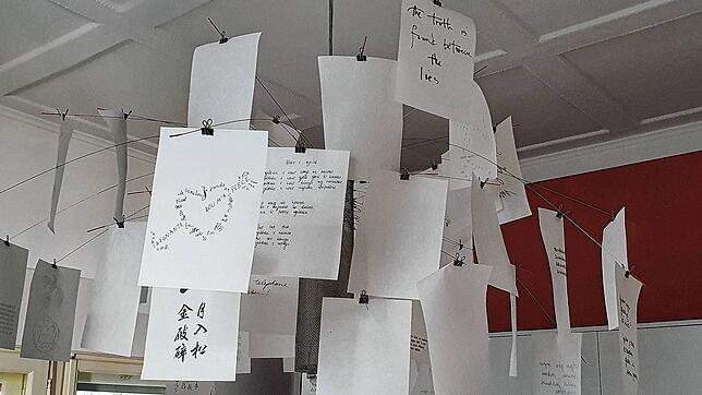 Sprüche an der Decke eines Hospiz-Gruppenraums. Auf einem Zettel steht, in Englisch: Die Wahrheit findet sich zwischen den Lügen.