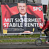 Ein Radfahrer fährt im Frankfurter Osten an zwei Wahlplakaten mit den Spitzenkandidaten von SPD und Union, Kanzler Olaf Scholz (l) und ...